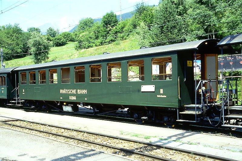 RhB - B 2246 am 04.07.1999 in Filisur - 2.Klasse Personenwagen - Baujahr 1928 - SIG/RhB - Fahrzeuggewicht 17,00t - Sitzpltze 72 - LP 16,55m - zulssige Geschwindigkeit 70 km/h - 2=02.10.1998 - Lebenslauf: ex ChA C4 52 - 1942 RhB C4 2246 - 1956 B4 2246 - 1954 B 2246 - Hinweis: Historisches Fahrzeug.

