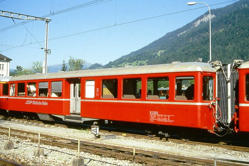 RhB - B 2302 am 24.08.2000 in Reichenau - 2.Klasse Mitteleinstiegs-Personenwagen Fliegender Rhtier - bernahme 1939 - SWS/SIG - Fahrzeuggewicht 18,00t - Sitzpltze 64 - LP 17,73m - zulssige Geschwindigkeit 90 km/h - 2=07.12.1992 1=17.05.2000 - Logo RhB in deutsch - Lebenslauf: ex C4 2302 - 1956 B4 2302 - 1964 B 2302
