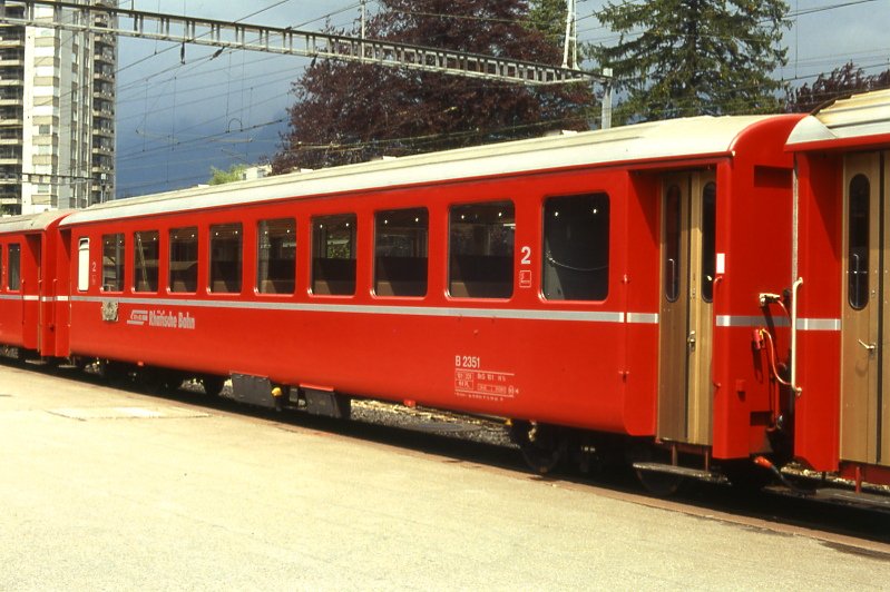 RhB - B 2351 am 15.05.1991 in Landquart - 2.Klasse Einheitspersonenwagen (Typ 1) - bernahme 19.06.1964 - FFA/SIG/RhB - Fahrzeuggewicht 18,00t - Sitzpltze 64 - LP 18,42m - zulssige Geschwindigkeit 90 km/h - Logo RhB in deutsch - 2=12.09.1986 - Lebenslauf: ex B4 2351 - 1964 B 2351 - Hinweis: Klassezahlen klein, hoher Anschriftenblock, schlanke Betriebsnummern, Griffstangen neben den Tren - ohne Kennzeichnung an den Ecken - die Fahrzeugserie besteht aus 33 Wagen mit den Nummern 2341 bis 2373. 
