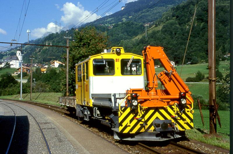 RhB BAUDIENSTZUG 9238 von Tavanasa nach Ilanz am 25.08.1997 in Tavanasa mit Traktor Tm 2/2 81 - Kkl 7070. Blick Richtung Kirche.
