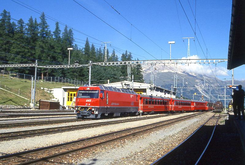 RhB BERNINA-EXPRESS B-Entlastungszug 2321 von Chur nach Tirano am 11.09.1995 Einfahrt Pontresina mit E-Lok Ge 4/4III 645 - B 2264 - B 2262 - BD 2371 - B 2466 - B 2468 - D 4035 - B 2462 - B 2091 - B - Gbkv 5528. Hinweis: Lok noch ohne Werbung! 
