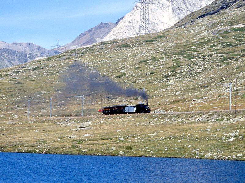 RhB Dampf-Extrazug fr GRUBNDEN TOURS 3456 von km 21,700 nach Ospizio Bernina am 26.08.2000 am Lago Nero mit Dampflok G 3/4 1 - Xk 9398 - B 2060 C 2012. Hinweis: dies ist der 3. Dampfzugeinsatz auf der Berninalinie seit Bahnbau! Teleaufnahme freihand, Entfernung 500m!  
