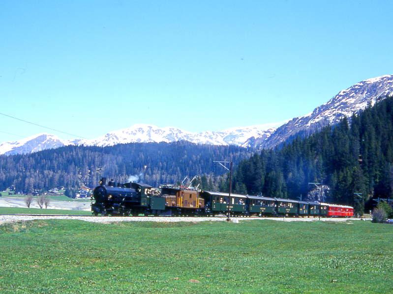 RhB Dampfextrazug fr die Dampffreunde der RhB 3031 von Landquart nach Davos Platz vom 10.05.1998 kurz vor Davos-Dorf mit Dampflok G 4/5 108 - Ge 6/6I 414 - B 2247 - B 2246 - B 2245 - B 4052I - B 2060 - B 1102 - B 2305 - B 2301. Hinweis: Normalerweise wird aus Lastgrnden den Dampfzgen die E-Lok vorgespannt. An diesen Einsatztag war eine Damfdoppelbespannung angekndigt und geplant, jedoch der Einsatz der Dampflok G 4/5 107 nicht mglich. Um die vielen extra angereisten Fotografen nicht zu enttuschen wurde vom Veranstalter ausnahmsweise die Dampflok als Vorspann angekuppelt. Wegen der extrem guten Teilnahme von etwa 350 Rundfahrt-Fahrgsten muten noch die 2 ehemaligen Fliegenden-Rhtier-Wagen am Zugschlu angehnt werden, da damals alle verfgbaren grnen Personenwagen schon in der Kompo eingereiht waren.