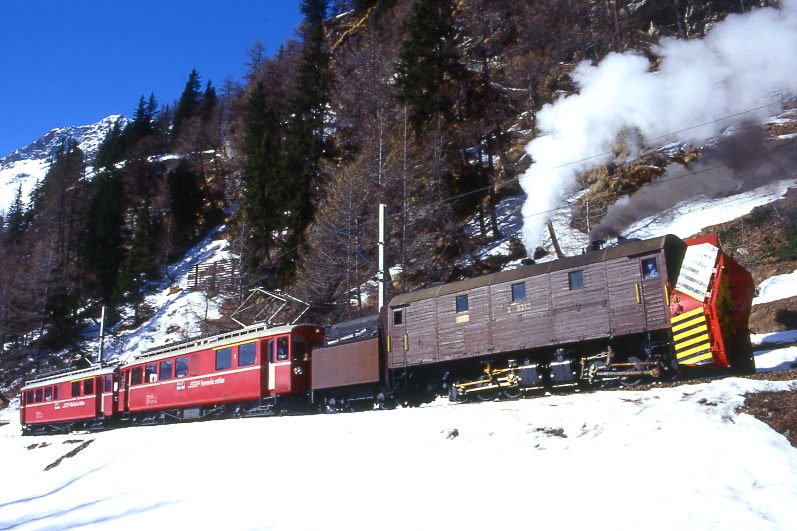 RhB Dampfschneeschleuder-Extrazug fr GRAUBNDEN TOURS 9448 von Cavaglia nach Alp Grm am 28.02.1998 bei La Dota zwischen Cavaglia und Alp Grm mit Dampfschneeschleuder X d rot 9213 - Triebwagen ABe 4/4I 30 - ABe 4/4 I 34. Hinweis: gescanntes Dia
