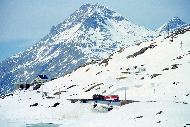 RhB - Dampfschneeschleuderextrazug 9462 fr Graubnden Tours von Alp Grm nach Ospizio Bernina am 21.02.1998 auf Brcke am See am Lago Bianco mit Dampfschneeschleuder X d rot 9213 - Triebwagen ABe 4/4 II 49. Hinweis: gescanntes Dia.
