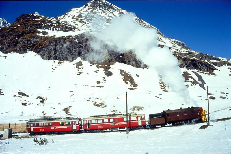 RhB - Dampfschneeschleuderextrazug 9462.2 fr Graubnden Tours von Alp Grm nach Ospizio Bernina am 28.02.1998 oberhalb Alp Grm mit Dampfschneeschleuder X d rot 9213 - Triebwagen ABe 4/4 I 30 + ABe 4/4 I 30. Hinweis: Triebwagen verkehren heute in gelber Lackierung, gescanntes Dia.

