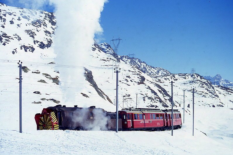RhB - Dampfschneeschleuderextrazug 9462.2 fr Graubnden Tours von Alp Grm nach Ospizio Bernina am 28.02.1998 am Lago Bianco mit Dampfschneeschleuder X d rot 9213 - Triebwagen ABe 4/4 I 30 + ABe 4/4 I 30. Hinweis: Triebwagen verkehren heute in gelber Lackierung, gescanntes Dia.
