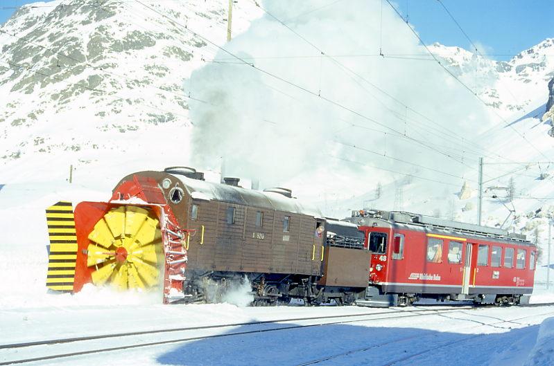 RhB Dampfschneeschleuderfahrtextrazug fr GRAUBNDEN TOURS 4411 von Bernina Suot nach Bernina Lagalb am 08.02.1997 Einfahrt Bernina Lagapb mit Xrot d 9213 - ABe 4/4II 48.
