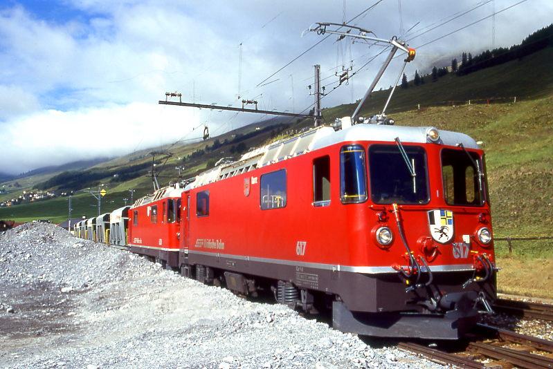RhB Extra - GTERZUG 6717 von Samedan nach S-chanf am 04.09.1996 in S-chanf mit E-Lok Ge 4/4II 617 - Ge 4/4II 630 - Fad 8731 - Fad 8726 - Fad 8736 - Fad 8727 - Fad 8738 - Fad 8733 - Fad 8739 - Fad 8728. Hinweis: Hier im Bahnhofsbereich wird das in der Nhe von S-chanf geschrfte Rohmaterial zwischengelagert, mit Radlader verladen und nach Bedarf in Blockzgen zu 8 Fad ins Betonwerk nach Davos-Frauenkirch befrdert. Die Doppelbespannung ist fr die Rckfahrt ber Albula ntig. Beladen ist die Zughakenlast gerade noch zulssige 420t bei 35? Steigung 
