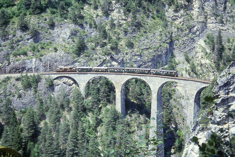 RhB Extrazug 3556 von Filisur nach Alvaneu fr BAHNFEST FILISUR am 04.07.1999 auf Landwasser-Viadukt mit E-Lok Ge 6/6 I 414 - D 4052II - C 2012 - B 2060 - B 2246 - B 2245. Hinweis: Foto: Margarete Mldner, gescanntes Dia

