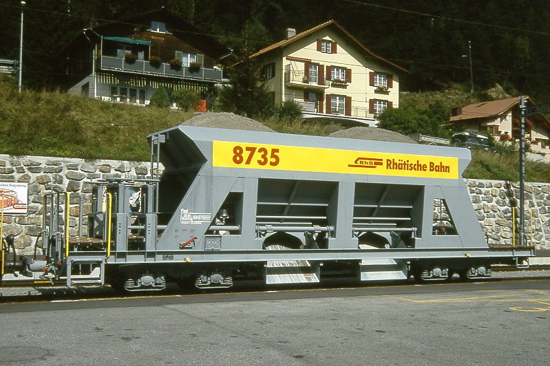 RhB - Fad 8735 am 01.09.1993 in Tiefencastel - Selbstentlade-Schotterwagen 4-achsig mit 1 offenen Plattform - bernahme 20.08.1993 - JMR - Gewicht 15,17t - Zuladung 33,00t - LP 12,50m - zulssige Geschwindigkeit 80/B km/h - Versuchslackierung Logo RhB in deutsch auf gelben Untergrund - Lebenslauf: ex Fad 8735 - 02/2004 Fac 8735.
