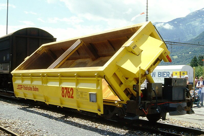 RhB - Fau 8762 am 08.06.1997 in Landquart Ried - Selbstentladwagen mit Kippvorrichtung, Einmuldenkipper 4-achsig mit 1 offenen Plattform - bernahme 27.03.1991 - NEVAG - Gewicht 21,05t - Zuladung 34,00t - LP 10,44m - zulssige Geschwindigkeit 80/B km/h - 2=25.02.1997 - Logo RhB in deutsch.
