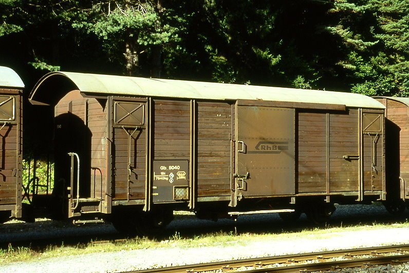 RhB - Gb 5040 am 01.09.1997 in Trin - Gedeckter Gterwagen 2-achsig mit 1 offenen Plattform - Baujahr 1963 - JMR - Gewicht 7,54t - Ladegewicht 15,00t - LP 9,14m - zulssige Geschwindigkeit Aufkleber 70/B km/h - Lebenslauf: ex K 5040 - 1969 Gb 5040 - 03/2000a - 06/2000 Lbv 7879 Tragwagen - Hinweis: genderte zulssige Geschwindigkeit, mit Kennzeichnung B fr Zugreihe im Anschriftenblock, gescanntes Dia
