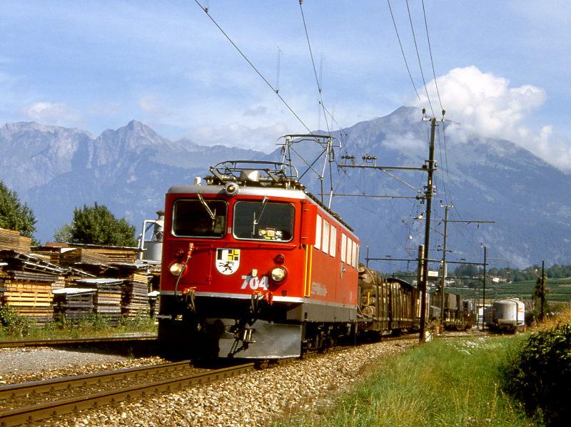 RhB Gterzug 4537 von Landquart nach St.Moritz vom 06.09.1994 Ausfahrt Untervaz mit E-Lok Ge 6/6II 704 - X 9094 - Rpw 8297 - Rw 8375 - Gb 5817 - Rw 8207 - X 9018 - Skpw 8416 - Rw 8260 - Rw 8209 - Rp 8226 - Kw 7507 - Kkw 7378 - Kkw 7373 - Kw 7504. Hinweis: die 4-Tausender-Zugnummer sagt aus, da der Gterzug ein GmP ist, allerdings erst ab Tusis. Ab Thusis wird also planmig ein Personenwagen hinter der Lok mitgefhrt! 
