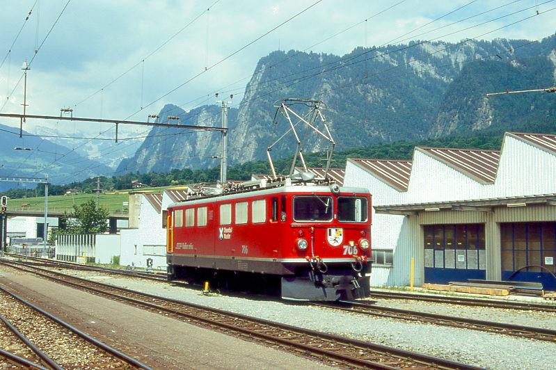 RhB Gterzug 5252 von Ilanz nach Landquart am 26.06.1995 Ausfahrt Untervaz mit E-Lok Ge 6/6 II 706 solo. Hinweis: Lok noch mit Scherenpantograf, Zughakenlast bereits komplett abgekuppelt.
