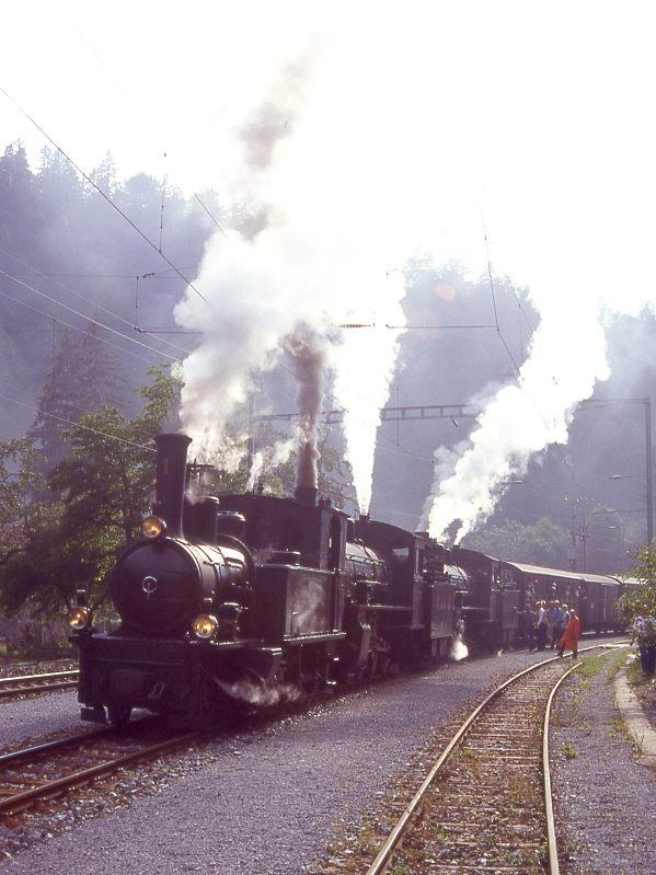 RhB Kursbuch-Dampfzug 6766 von Disentis nach Landquart vom 27.08.1995 in Trin mit Dampflok-Dreifachbespannung G 3/4 1 - G 4/5 108 - G 4/5 107 - B 2247 - D 4052I - B 2246 - A 1102 - B 2060 - B 2245 - B 2218 - B 2217. Hinweis: Aufnahme im Gegenlicht.