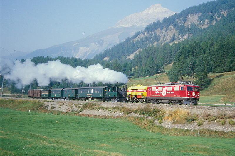 RhB Lsch- und Dampf-GmP 3534 von Samedan nach Landquart am 27.08.2000 zwischen Samedan und Bever mit E-Lok Ge 4/4I 601 - Xk 9049II - G 3/4 1 - B 2246 - D 4052II - B 2060 - C 2012 - Gbkv 5565 - Gbkv 5575. Hinweis: Lschzugvorspann wegen Albulatunnel bis Preda, gescanntes Dia
