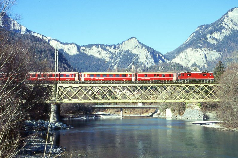 RhB Regionalzug 254 von Disentis nach Chur am 27.02.1998 auf Rheinbrcke bei Reichenau mit E-Lok Ge 4/4 II 619 - B 2376 - B 2383 - B 2339 - A 1232 - D 4218. Hinweis: gescanntes Dia
