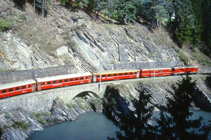 RhB Regionalzug 254 von Disentis nach Chur am 25.04.1999 bei Hochwassermarke zwischen Trin und Reichenau mit E-Lok Ge 4/4 II 615 - D - A - 4xB. Hinweis: gescanntes Dia
