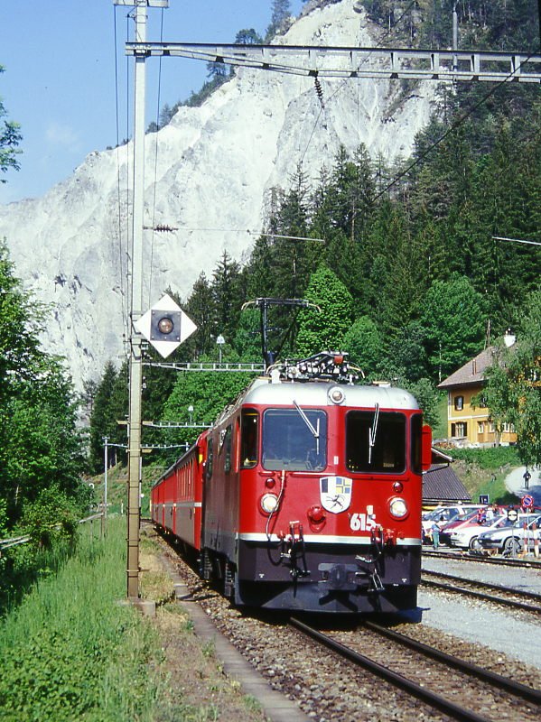 RhB Regionalzug 261 von Chur nach Disentis am 23.05.1998 in Valendas-Sagogn mit E-Lok Ge 4/4 II 615 - B 2449  - B 2361 - B 2344 - A 1236 - D 4223. Hochformat, Hinweis: gescanntes Dia
