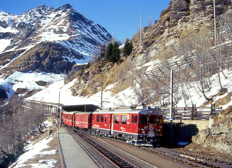 RhB REGIONALZUG 445 von St.Moritz nach Tirano am 09.03.1998 Einfahrt Alp Grm mit Triebwagen ABe 4/4III 54 - DZ 4036 -B 2233 - B 2307 - B 2312 - B 2259 - Lbv 7852.
