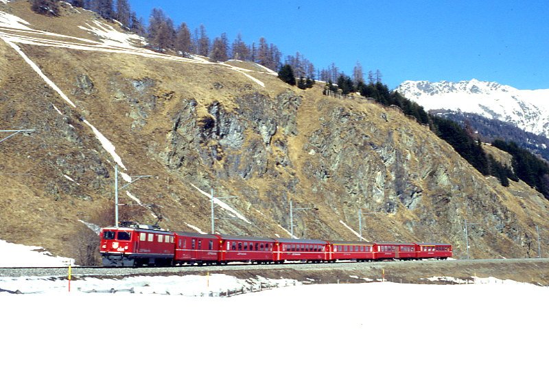 RhB Regionalzug 750 von Scuol nach St.Moritz am 26.02.1998 zwischen Samedan und Celerina mit E-Lok Ge 4/4 I 604 - D - 2x B - A - B - AB. Hinweis: seit 22.11.1999 keine planmig durchgehende Zge mehr von Scuol nach St.Moritz, Kompo um 2 Wagen verstrkt wegen Engadiner Skimarathon, gescanntes Dia
