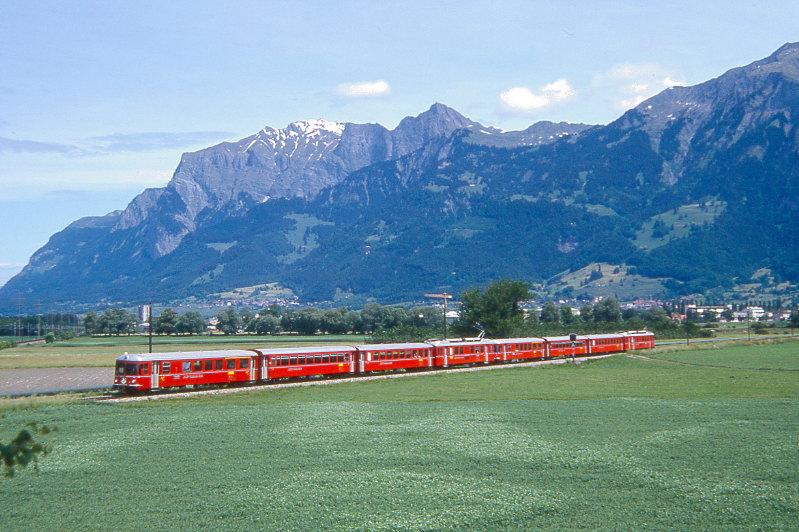 RhB Regionalzug 841 Doppel-Vorortpendel von Landquart nach Chur am 01.06.1992 zwischen Igis und Zizers mit Steuerwagen voraus ABDt 1711 - B 2417 - B 2411 - Be 4/4 511 - ABDt 1713 - B 2419 - B 2413 - Be 4/4 513.
