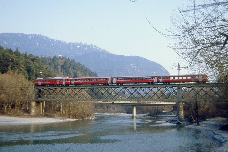 RhB Regionalzug 872 von Thusis nach Chur am 11.04.1992 auf Rheinbrcke bei Reichenau mit Triebwagen Be 4/4 514 - B - B - ABDt 1714. -Hinweis: Hier mal die Rheinbrcke von Norden aus aufgenommen genau am Beginn des Alpenrheins. Aus dem Oberalpgebiet und Oberland kommt im Bildvordergrund der Vorderrhein. Aus dem Bildhintergrund kommt vom Rheinwaldhorn der Hinterrhein und vereinigt sich mit dem Vorderrhein zum Alpenrhein, der hier im Bild beginnend nach links zum Bodensee abfliet.  Die Eisenbahnbrcke berspannt also den Hinterrhein, gescanntes Dia
