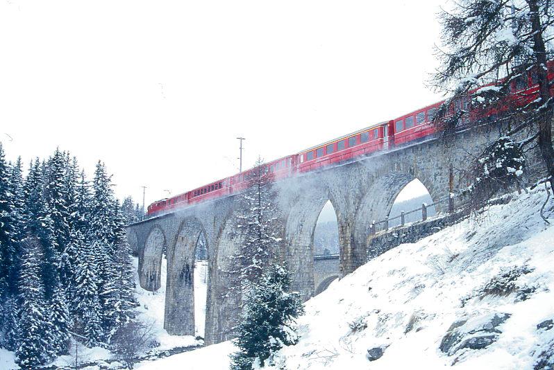 RhB REGIONALZUG von Scuol nach St.Moritz am 12.04.1998 auf Val Susauna-Viadukt mit E-Lok Ge 4/4II 623 - D - 2B - A - B.Hinweis: Ostersonntag bei Schneefall.
