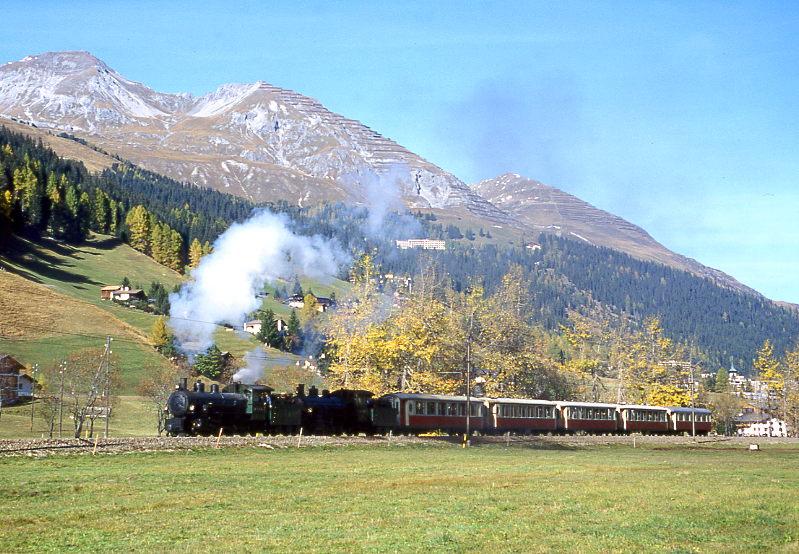 RhB Salon-Dampfzug 3153 f�r GRAUB�NDEN TOURS von Davos-Platz nach Filisur vom 25.10.1997 in Davos-Islen mit Dampflok-Doppelbespannung G 4/5 107 - G 4/5 108 - As 1144 - As 1142 - As 1141 - As 1143 - As 1161. Hinweis: Hier in Davos-Islen wurde f�r die Fotografen und Filmer der Zug zur�ckgesetzt und eine Scheinanfahrt durchgef�hrt. Von dieser Seite ist gute Sonne bis 15:00h zur Sommerzeit. Wie aus den beiden Fotos erkennbar ist, war der Zug zum Aufnahmezeitpunkt genau in Sonnenrichtung unterwegs.