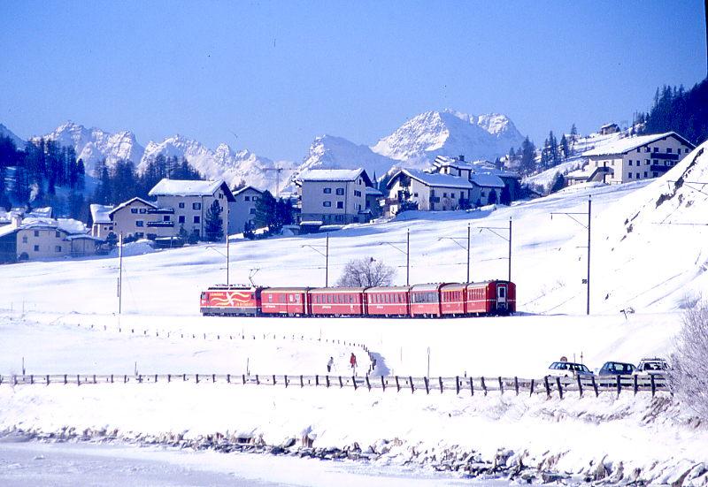RhB Schnellzug 521 von Chur nach St.Moritz am 01.02.1998 kurz vor Celerina mit E-Lok Ge 4/4III 648 - D - B - B - B - A - A. Hinweis: Lok hat noch alte Vereina-Werbung! Blick ber den Inn Richtung Westen.