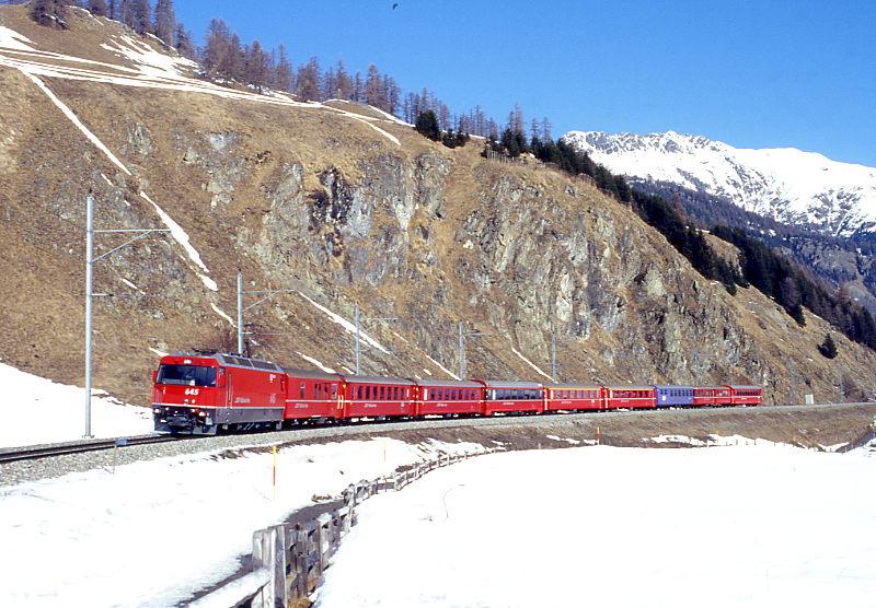 RhB Schnellzug 525 von Chur nach St.Moritz am 26.02.1998 zwischen Samedan und Celerina mit E-Lok Ge 4/4III 645 - D - B - B - B - A - A - WR - B - B:. Hinweis: Lok noch ohne Werbung!  