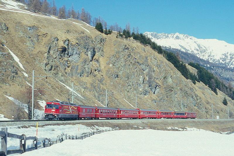 RhB Schnellzug 535 von Chur nach St.Moritz am 26.02.1998 zwischen Samedan und Celerina mit E-Lok Ge 4/4III 648 - D 4216 - B 2435 - B 2381 - B 2392 - A 1281 - A 1272 - B. Hinweis: Lok mit Werbung: VEREINA, gescanntes Dia
