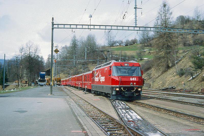 RhB Schnellzug 535 von Chur nach St.Moritz am 11.04.1998 Einfahrt Filisur mit E-Lok Ge 4/4III 641 - D 1216 - B 2358 - B 2377 - B 2391 - A 1228 - A 1241 - WR 3811 - B 2269. Hinweis: Lok mit Werbung BERNINA-EXPRESS, gescanntes Dia
