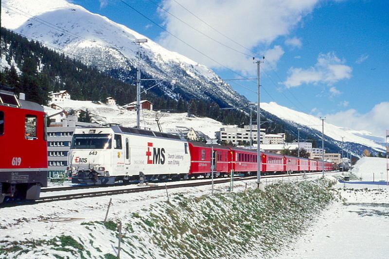 RhB Schnellzug 535 von Chur nach St.Moritz am 04.10.1999 Einfahrt Samedan mit E-Lok Ge 4/4III 643 - D - 3xB - 2xA - 3xB. Hinweis: Lok mit Werbung EMS-Chemie, gescanntes Dia
