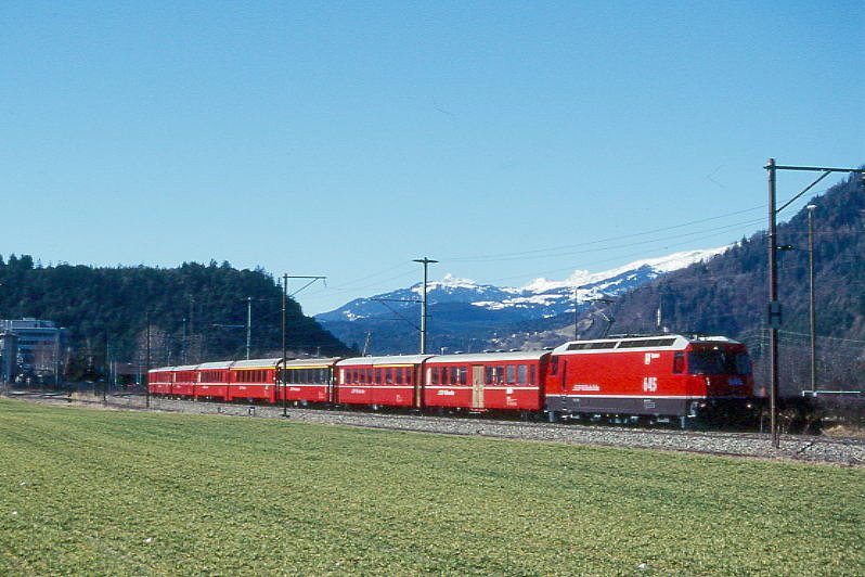 RhB Schnellzug 540 von St.Moritz nach Chur am 27.02.1998 bei Ems Werk mit E-Lok Ge 4/4III 645 - B 2325 - AB 1528 - A 1272 - A 1281 - B 2392 - B 2381 - B 2345 - D 4220. Hinweis: Lok ohne Werbung, gescanntes Dia
