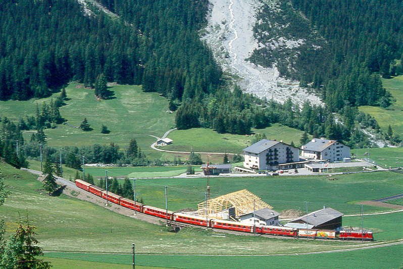 RhB Schnellzug 544 von St.Moritz nach Chur am 08.06.1993 kurz vor Bergn mit E-Lok Ge 4/4II 628 - Haikqy - B - 2x A - 3x B - D. Hinweis: Zug auf der unteren Rampe, gescanntes Dia
