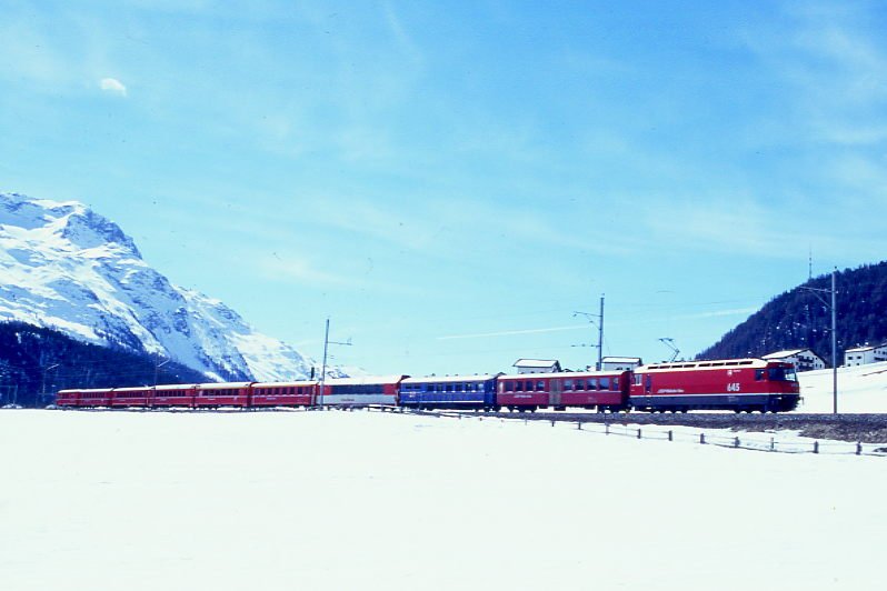 RhB Schnellzug 550 von St.Moritz nach Chur am 06.03.1998 zwischen Celerina und Samedan mit E-Lok Ge 4/4 III 645 - B 2323 - WR 3812 - FO PS 4012 - A 1222 - A 1282 - B 2393 - B 2350 - B 2326 - D 4221. Hinweis: gescanntes Dia
