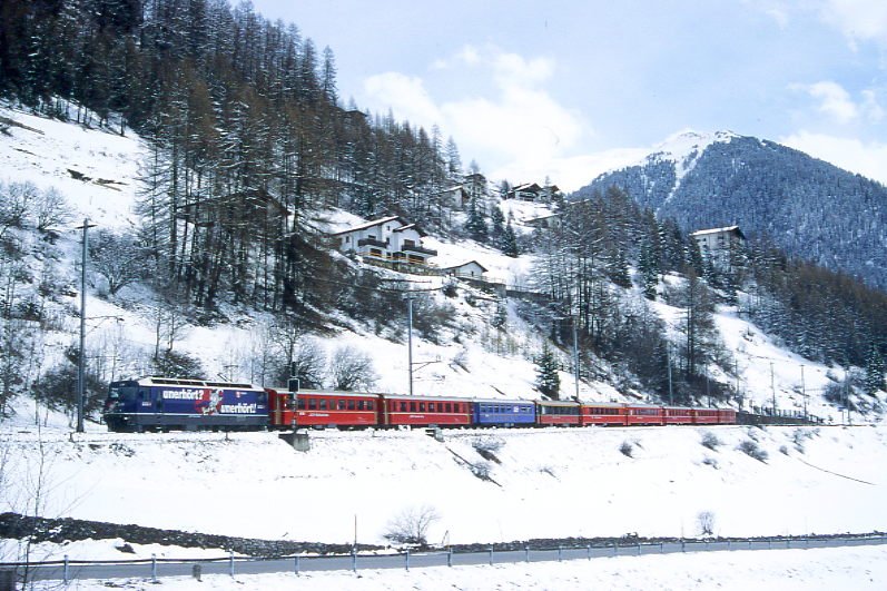 RhB Schnellzug 550 von St.Moritz nach Chur am 11.04.1998 bei Bergn mit E-Lok Ge 4/4 III 644 - B 2253 - B 2436 - WR 3810 - A 1262 - A 1282 - B 2393 - B 2379 - B 2426 - D 4209. Hinweis: gescanntes Dia
