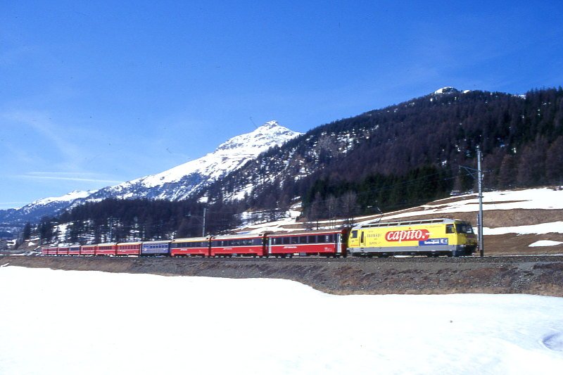 RhB Schnellzug 550 von St.Moritz nach Chur am 12.03.2000 zwischen Samedan und Bever mit E-Lok Ge 4/4 III 647 - B 2461 - B 2494 - A 1273 - WR 3810 - A(WR-S) 1223 - A 1282 - A 1240 - B 2491 - B 2364 - B 2443 - D 4217. Hinweis: gescanntes Dia
