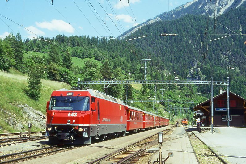 RhB Schnellzug 554 von St.Moritz nach Chur am 27.06.1995 in Filisur mit E-Lok Ge 4/4 III 643 - B 2253 - A 1233 - A 1232 - B  2449 - B 2442 - B 2345 - D 4219. Hinweis: Lok noch ohne Werbung, gescanntes Dia

