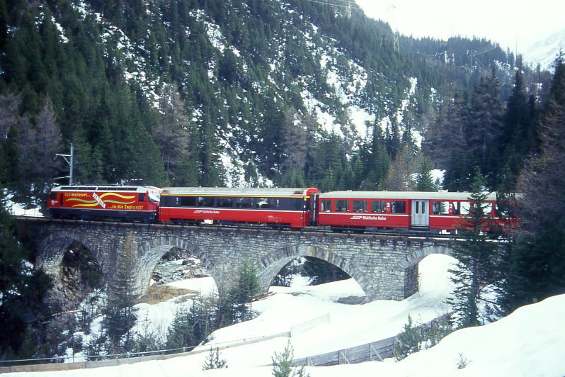 RhB Schnellzug 554 von St.Moritz nach Chur am 03.03.1998 auf Albula I-Viadukt zwischen Preda und Muot mit E-Lok Ge 4/4 III 648 - A 1273 - B - 2x A - 3x B - D. Hinweis: gescanntes Dia
