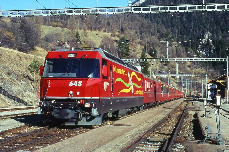 RhB Schnellzug 560 von St.Moritz nach Chur am 26.02.1998 in Filisur mit E-Lok Ge 4/4 III 648 - B - A 1272 - A 1281 - B 2392 - B 2381 - B 2425 - D 4215. Hinweis: Lok noch mit alter Werbung: VEREINA, gescanntes Dia.
