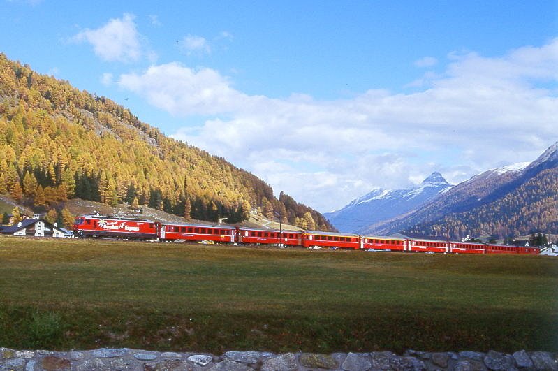 RhB Schnellzug 560 von St.Moritz nach Chur am 18.10.1998 im Val Bever zwischen Bever und Spinas mit E-Lok Ge 4/4 III 641 - 2x B - 2x A - 3x B - D. Hinweis: Lok noch mit alter Werbung: BERNINA-EXPRESS, gescanntes Dia.
