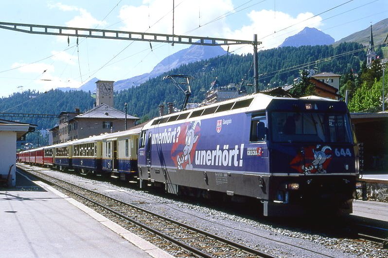 RhB Schnellzug 564 von St.Moritz nach Chur am 28.08.1998 in St.Moritz mit E-Lok Ge 4/4 III 648 - D 4062 - As 1143 - As 1144 - As 1141 - B 2369 - B 2359 - A 1225 - A 1227 - B 2382 - B 2374 - B 2369  - D 4218 - Z 13092 - Gbkv 5543. Hinweis: vorderer Zugteil ALPIN CLASSIC PULLMAN EXPRESS, starkes Gegenlicht, gescanntes Dia

