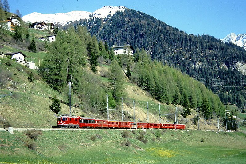 RhB Schnellzug 570 von St.Moritz nach Chur am 07.05.1994 Ausfahrt Bergn mit E-Lok Ge 4/4 II 617 - B 2492 - B 2324 - A 1233 - A 1224 - Br 2261 - B 2443 - B 2447 - B 2382 - D 4216. Hinweis: Beachtenswert ist die Plankompo mit 4 B-Wagen (blich sind 3x B zwischen A - A und D, gescanntes Dia
