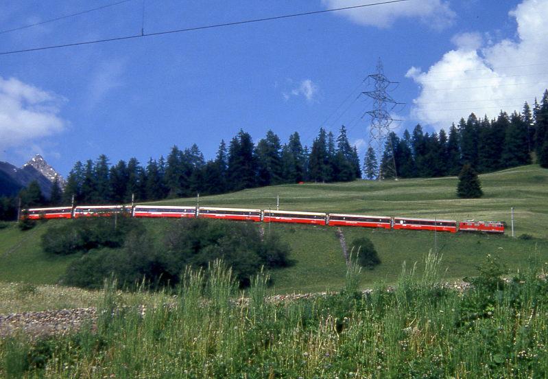RhB Schnellzug BERNINA-EXPRESS D 500 von Tirano nach Chur am 08.06.1993 oberhalb Bergn mit E-Lok Ge 4/4I 603 und EW-IV-Kompo. Hinweis: der Zug befindet sich auf der Mittleren Schleife und befhrt nach der nchsten Kehre den sichtbaren Bahndamm im Vordergrund, deutlich ist das 35-Promille-Geflle erkennbar.   
