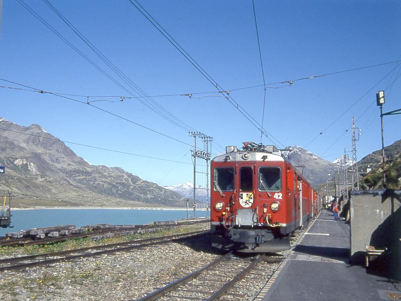 RhB Schnellzug BERNINA-EXPRESS F 417 von St.Moritz nach Tirano am 29.03.1993 in Ospizio Berninamit den Triebwagen ABe 4/4II 42 - ABe 4/4II 49 - AB 1543 - B 2462 - B 2466 - B 2460 - BD 2474 - B 2455 - B 2314. Hinweis: Blick auf Lago Binaco
