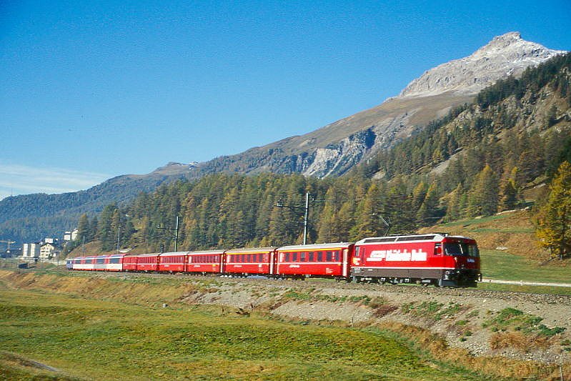RhB Schnellzug Glacier-Express 540 von St.Moritz nach Zermatt am 14.10.1999 zwischen Samedan und Bever mit E-Lok Ge 4/4 III 646 - A 1244 - A 1240 - B 2364 - B 2293 - B 2448 - D 4209 - FO AS 4026 - BVZ AS 2013 - FO AS 4030 - FO AS 4021 - WR 3810. Hinweis: Eigenwerbung nur kurze Zeit auf Lok, gescanntes Dia

