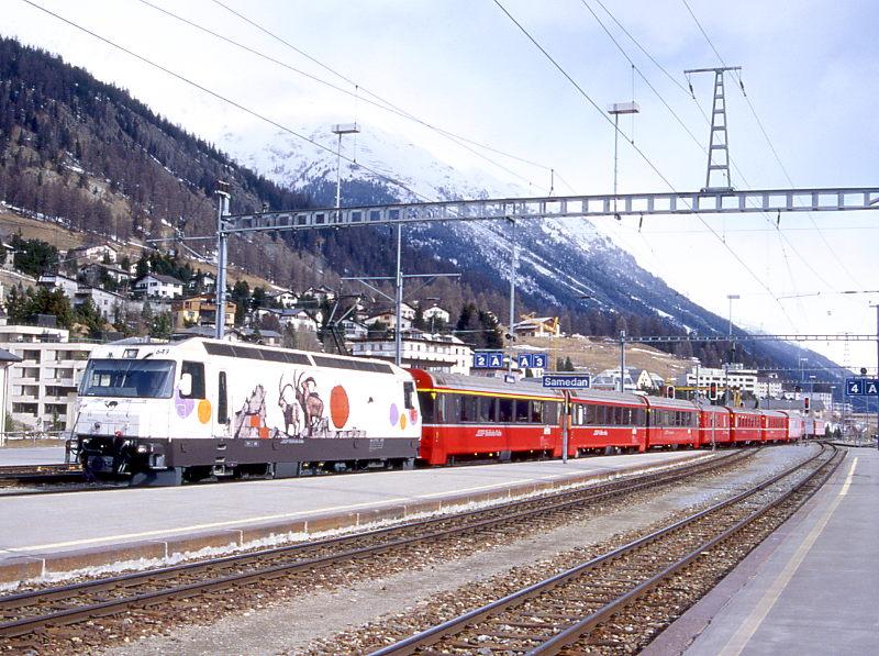 RhB Schnellzug WINTER-BERNINA-EXPRESS 525 von Chur nach St.Moritz am 15.03.2000 Einfahrt Samedan mit E-Lok Ge 4/4III 649 - A 1245 - B 2497 - BD 2475 - D 4216 -B  2378 - B 2376 - B 2391 - A 1223 - A 1266 - WR 3810 - B 2439. Hinweis: Lok hat noch alte BCU-Werbung, die vorderen drei Wagen gehen normalerweis direkt ber Pontresina nach Tirano. Wegen Streckensperrung und Zugausfall Samedan Pontresina und Pontresina - St.Moritz wurde der Bernina-Express zwischen Samedan und Pontresina mit Busersatzverkehr gefhrt! Speisewagen wurde wegen Wagenmangel ohne Bedienung mitgefhrt.